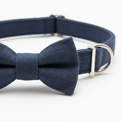 Close-up detail of navy blue bow tie knot and collar strap hardware